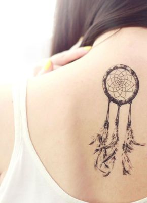  Tatouage attrape rêve avec des plumes soutenues par de longs files sur le milieu du dos